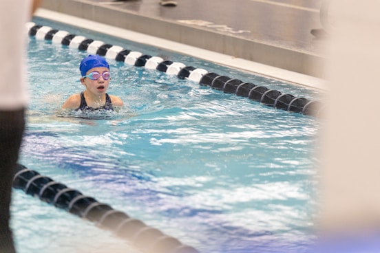 A girl swimming in a pool wearing a swimming cap