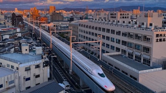 A train traveling through a city next to tall buildings
