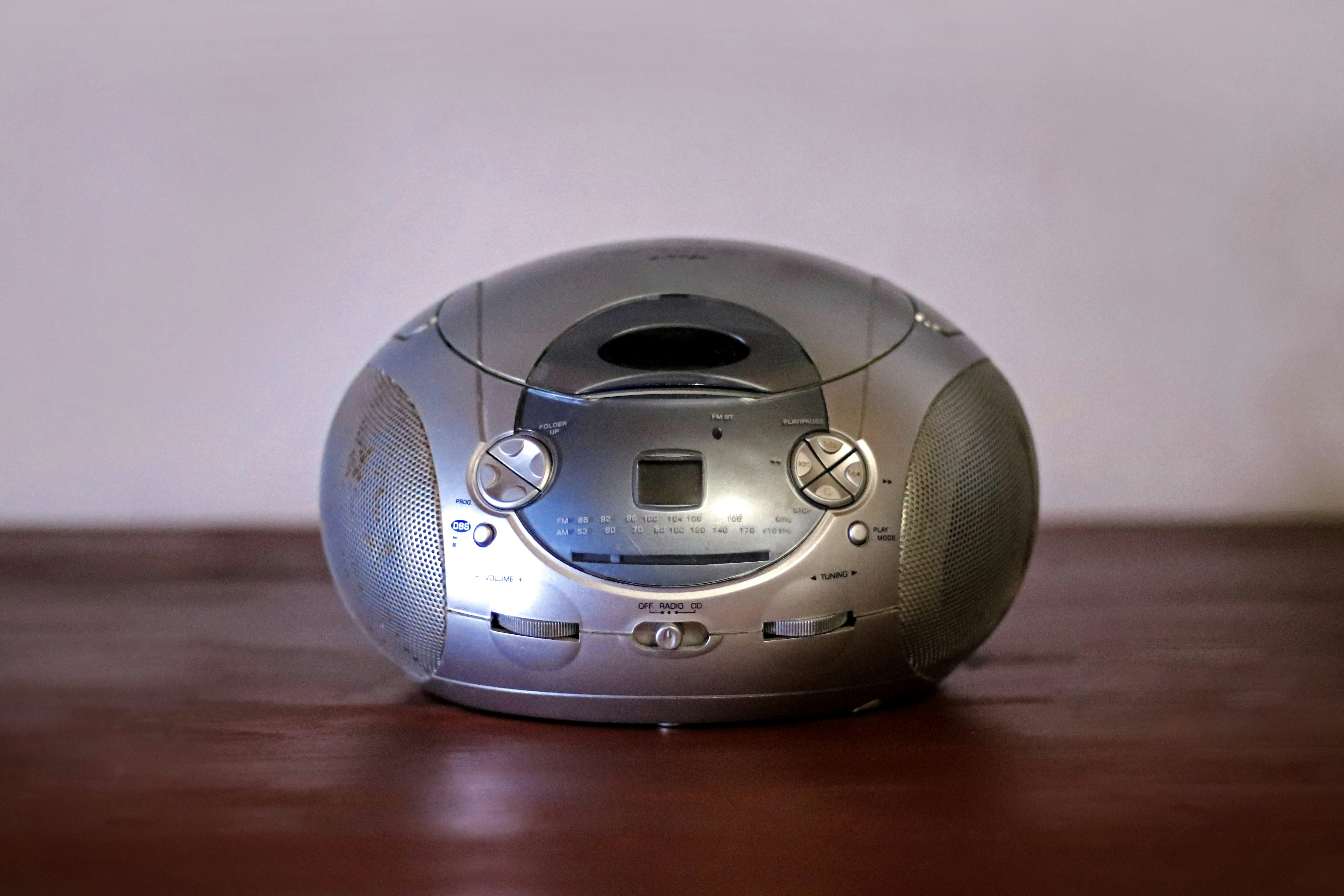 A silver alarm clock sitting on top of a wooden table
