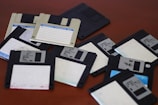 A pile of floppy disk drives sitting on top of a table