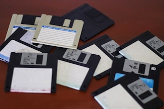 A pile of floppy disk drives sitting on top of a table