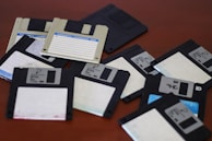 A pile of floppy disk drives sitting on top of a table