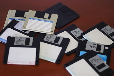 A pile of floppy disk drives sitting on top of a table