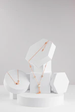 A set of three white boxes with gold necklaces