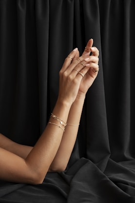 A woman sitting on a bed with her hands on her chest