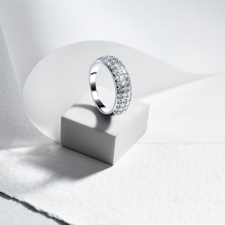 A diamond ring sitting on top of a white surface