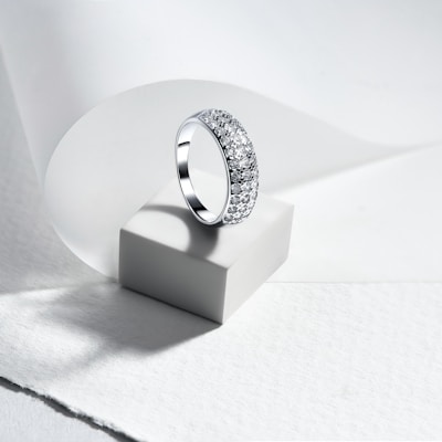 A diamond ring sitting on top of a white surface