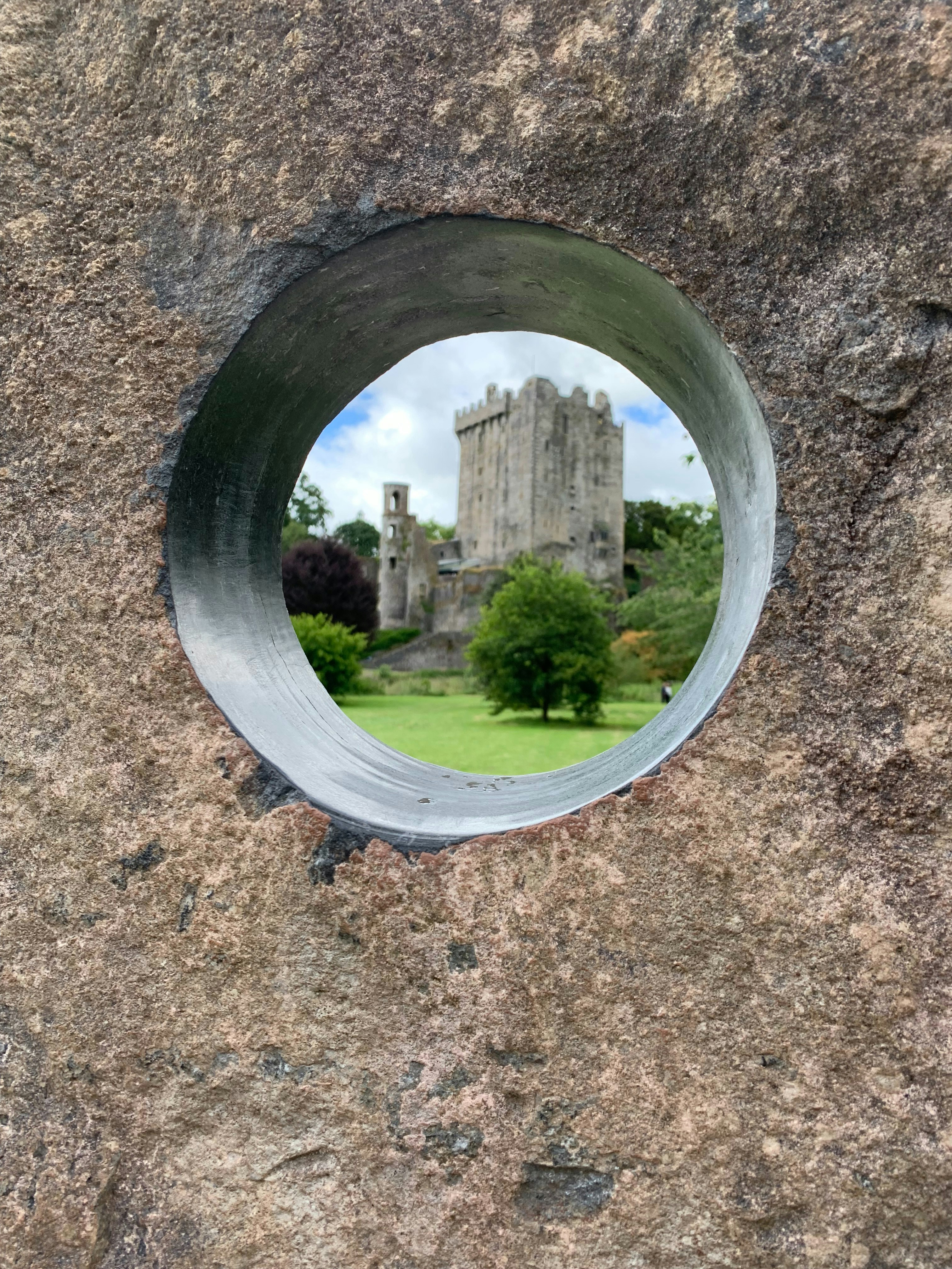 Uma vista de um castelo através de um buraco em uma rocha