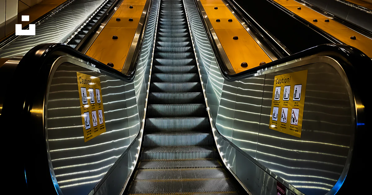 An escalator in a subway station with yellow railings photo – Free ...
