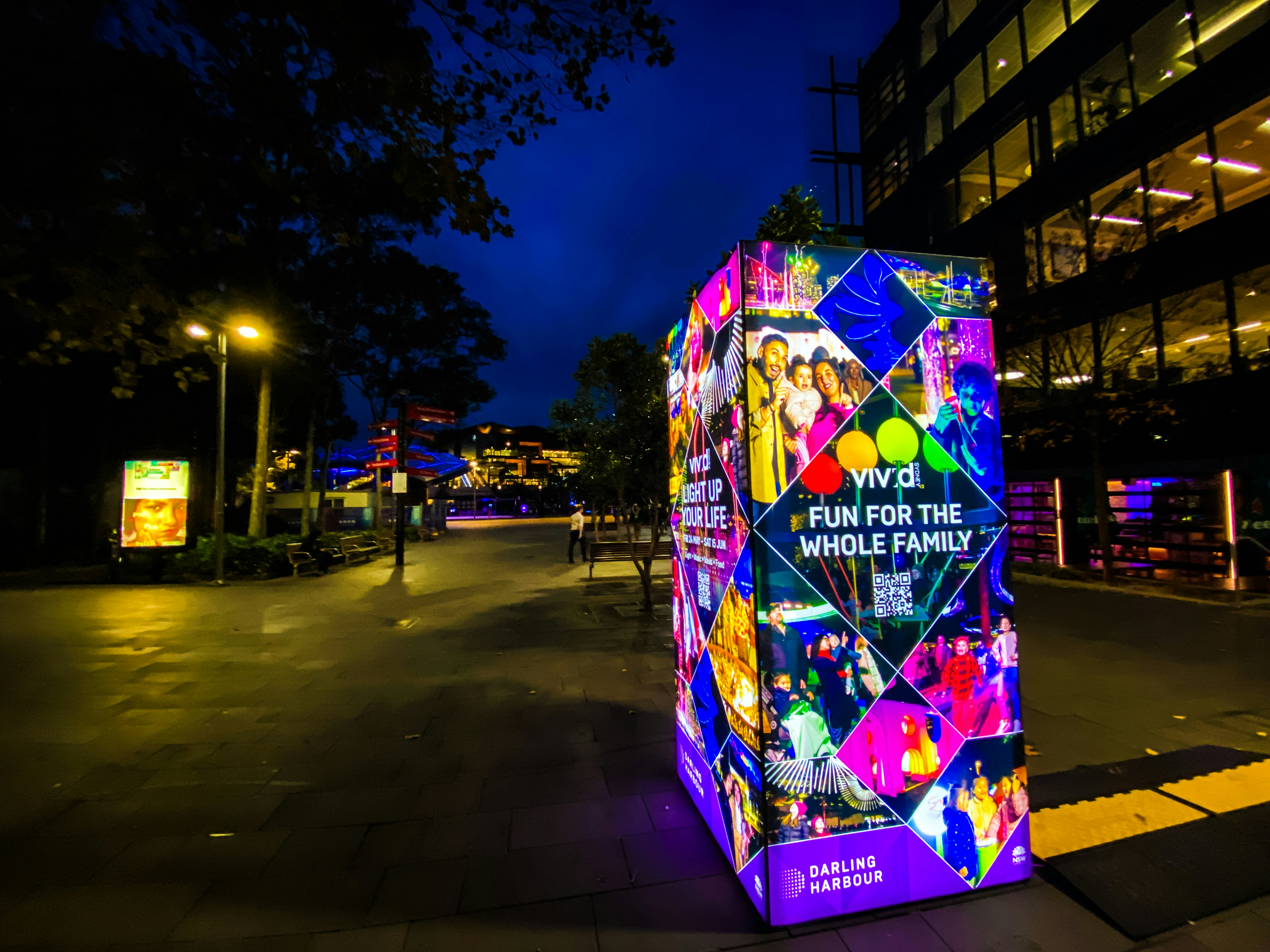 A brightly lit box sitting on the side of a road