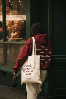 A woman walking down a street carrying a bag