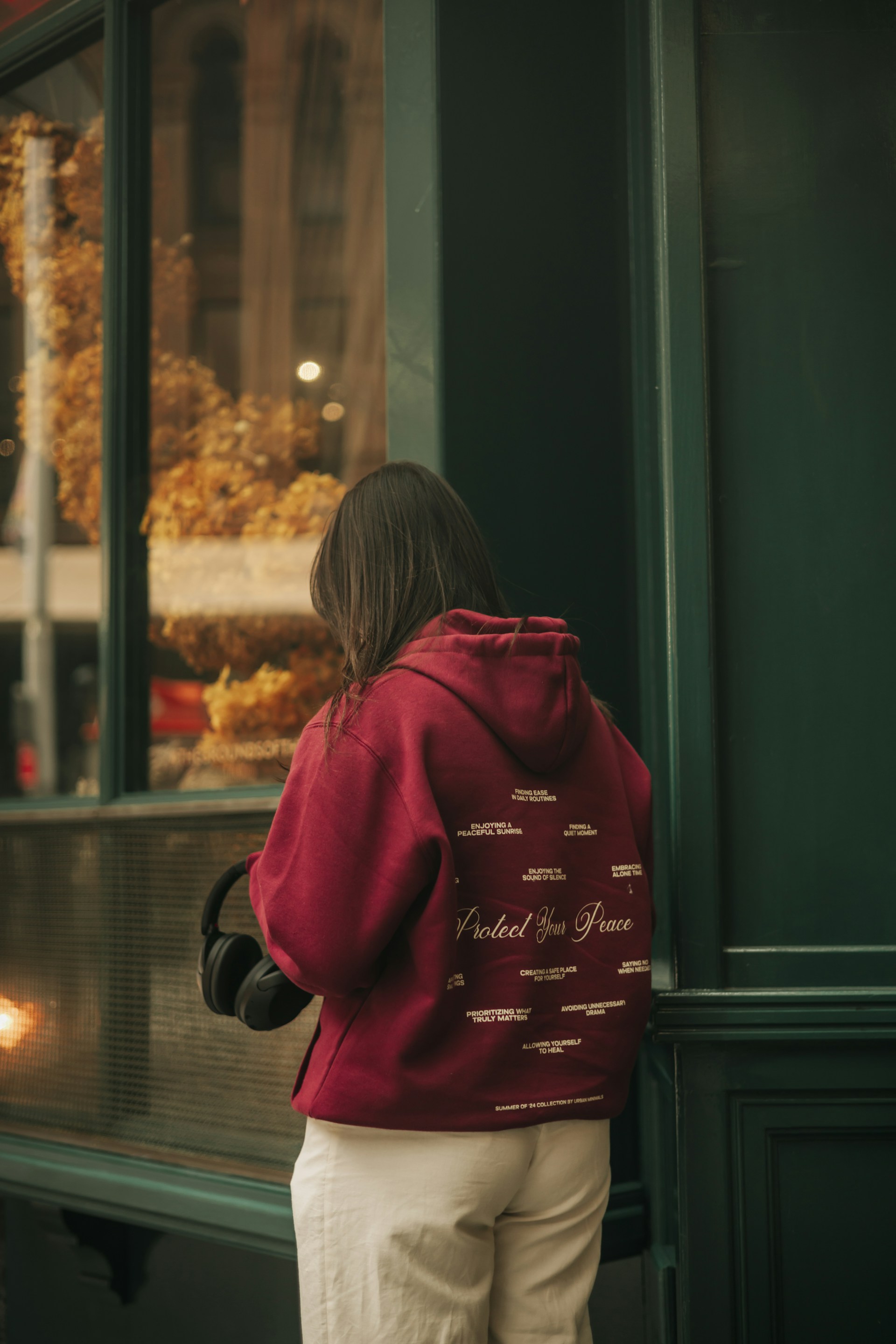 A woman standing in front of a store window
