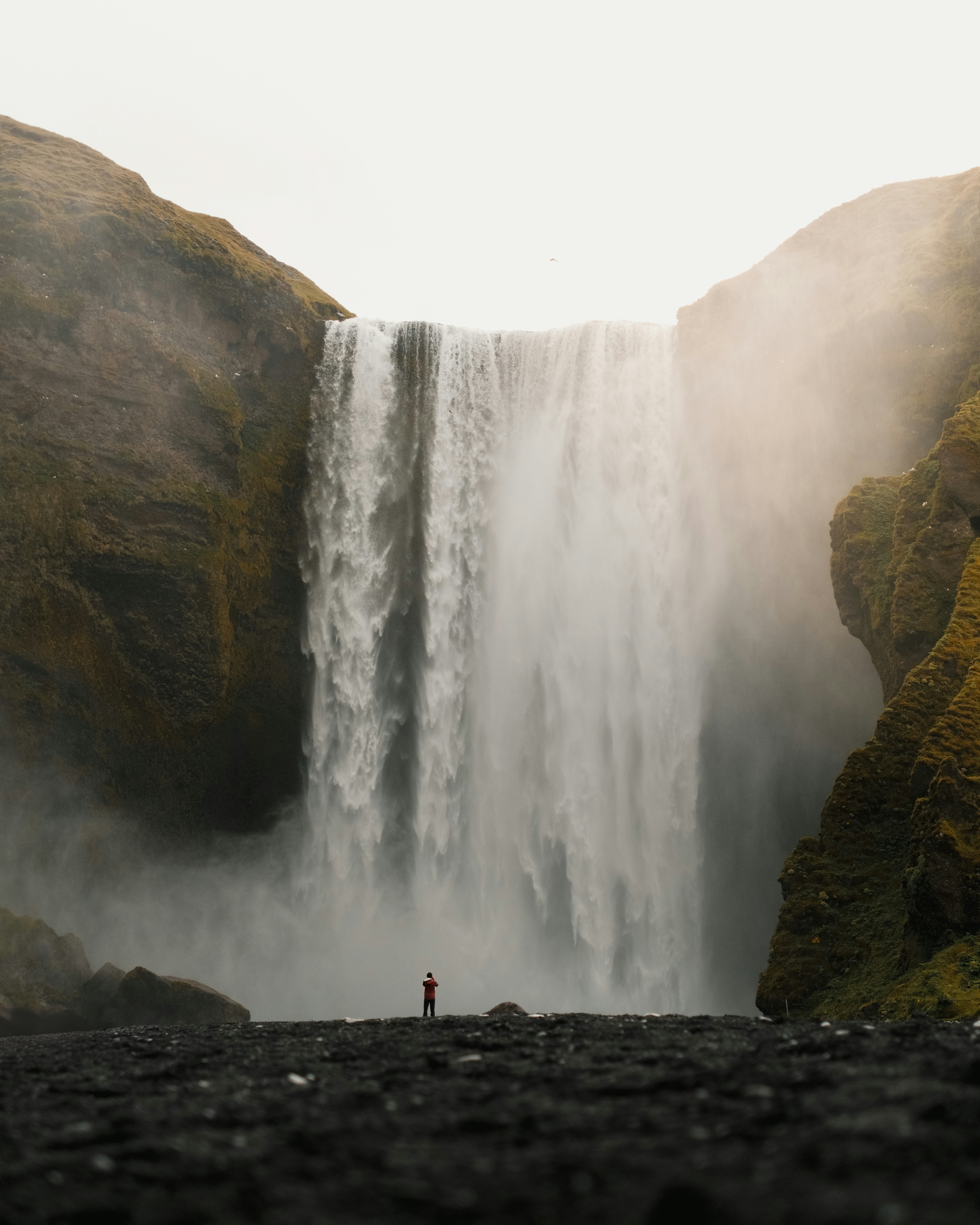 A person standing in front of a waterfall