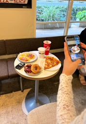 A woman taking a picture of food on her phone
