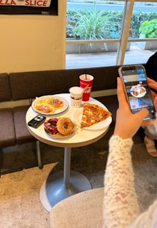 A woman taking a picture of food on her phone