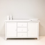 A bathroom with a white cabinet and white walls