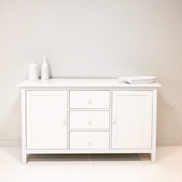 A bathroom with a white cabinet and white walls