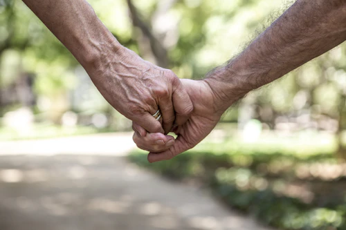 Close-up of two people holding hands