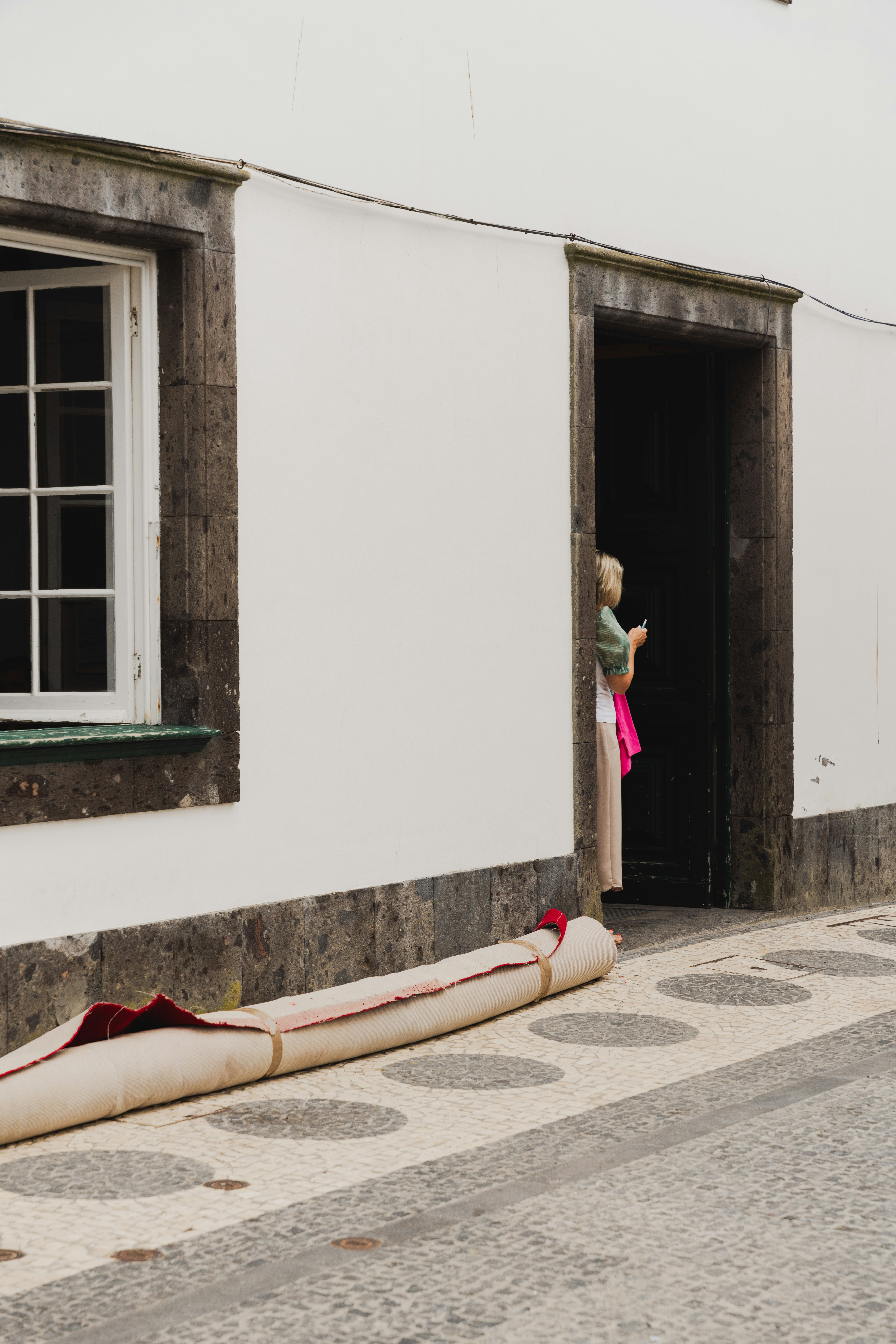 Uma mulher em pé em uma porta de um prédio branco