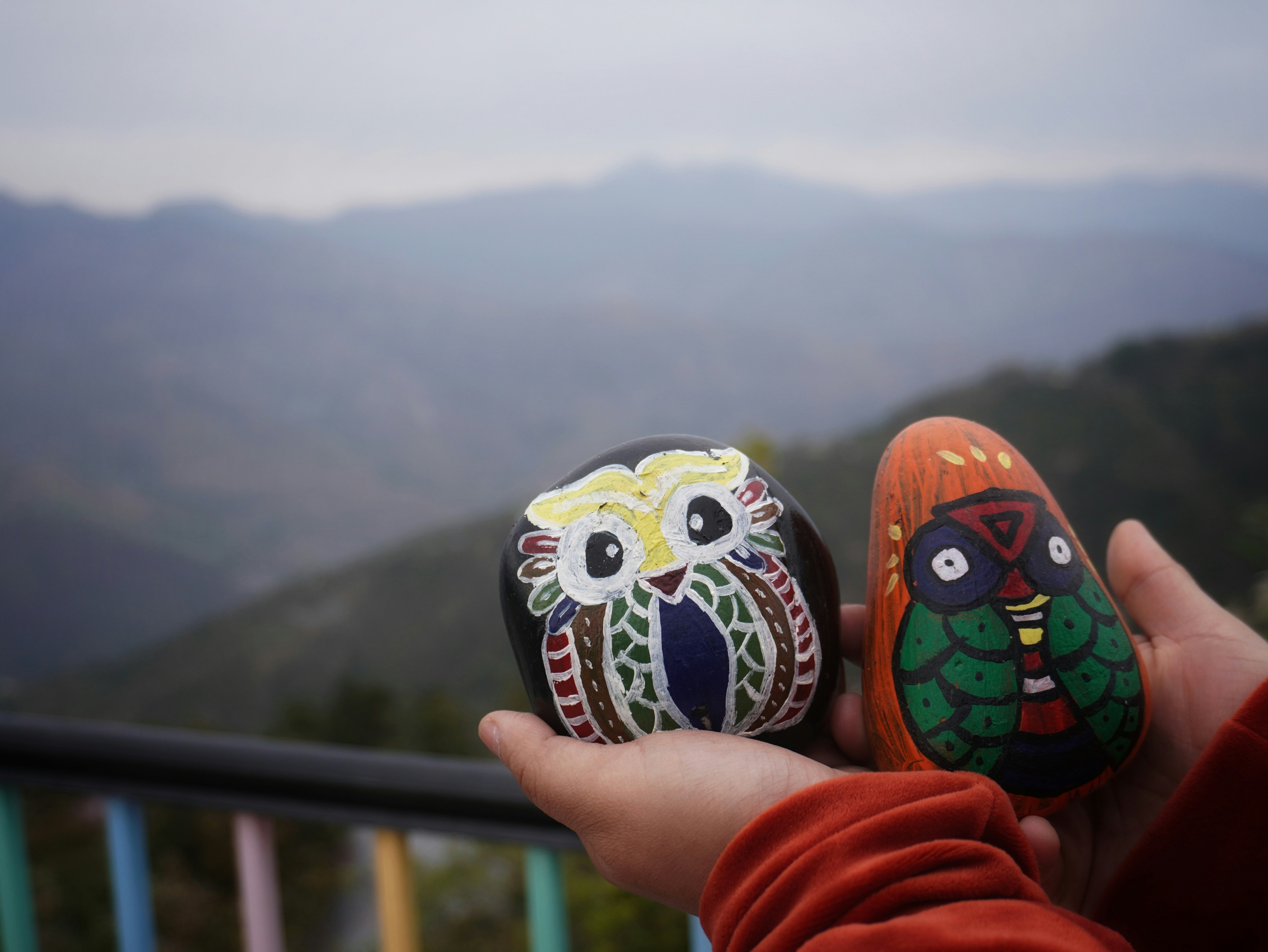 A person holding two painted rocks in their hands