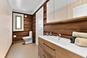 A bathroom with wood paneling and a white toilet