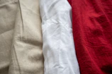 A close up of three different colored shirts