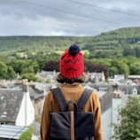 A person wearing a backpack and a red hat