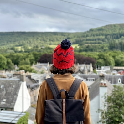 A person wearing a backpack and a red hat