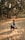 A man kneeling down in the sand with a baseball bat