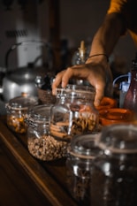A person reaching for a jar of food on a counter