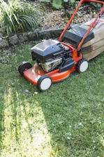 A lawn mower sitting on top of a lush green field