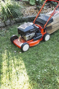 A lawn mower sitting on top of a lush green field