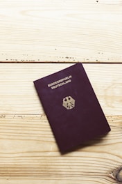 A purple passport sitting on top of a wooden table