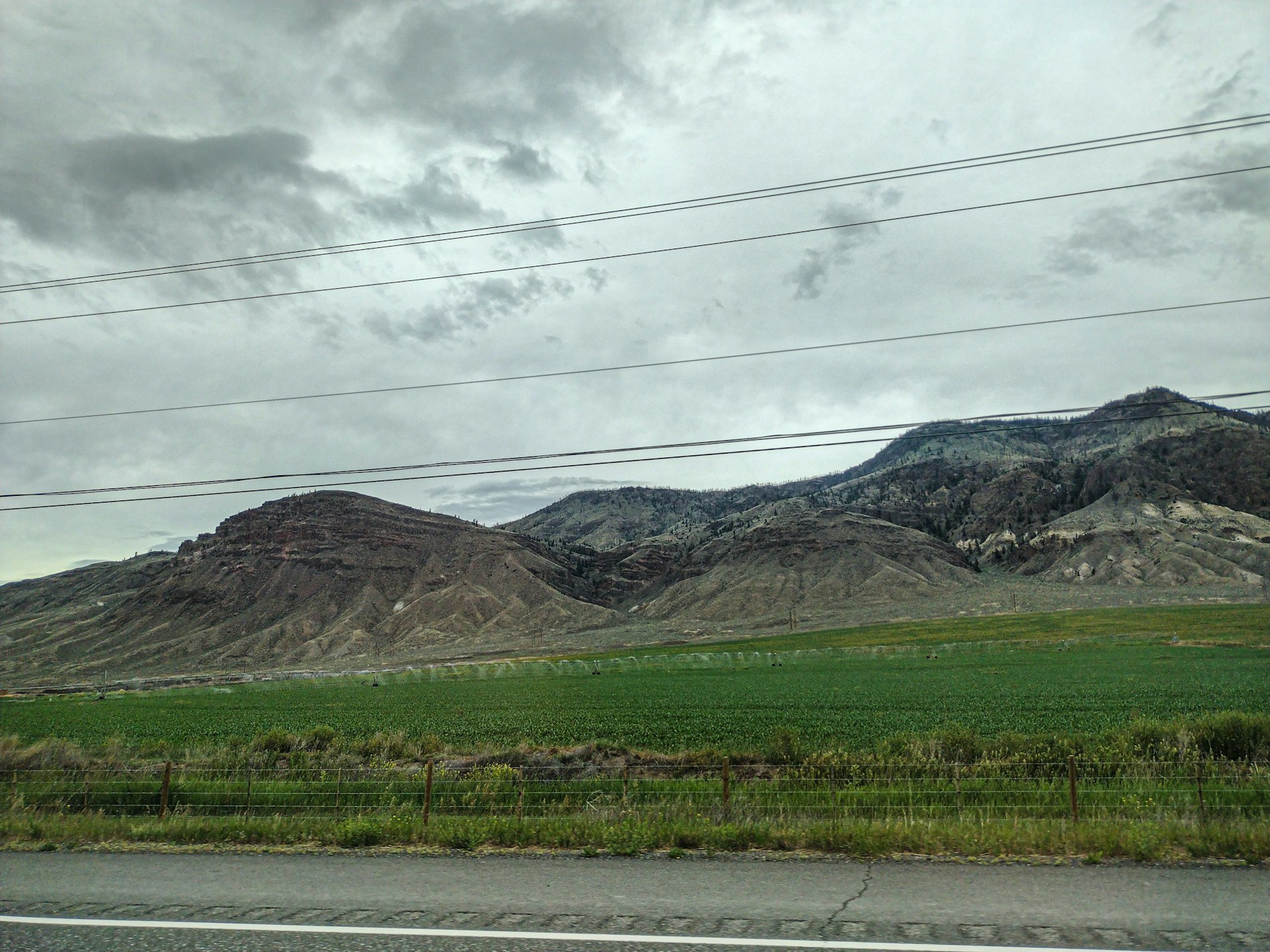 A view of mountains from the side of a road