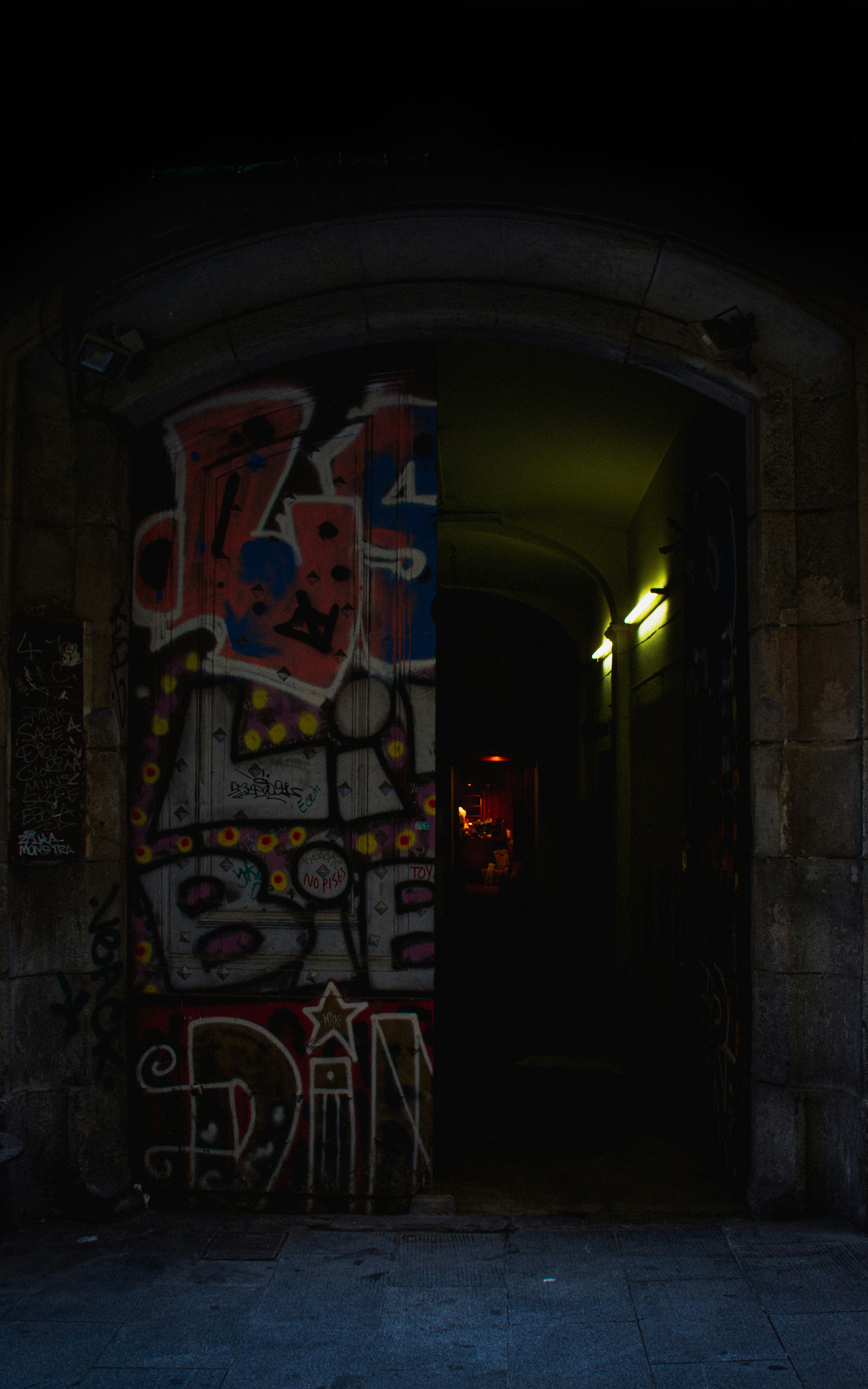 A door with graffiti on it in a dark room