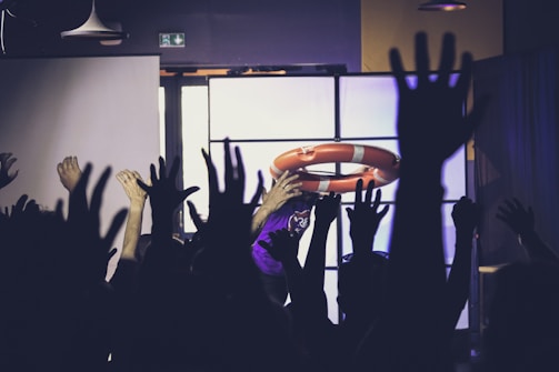 A group of people raising their hands in the air