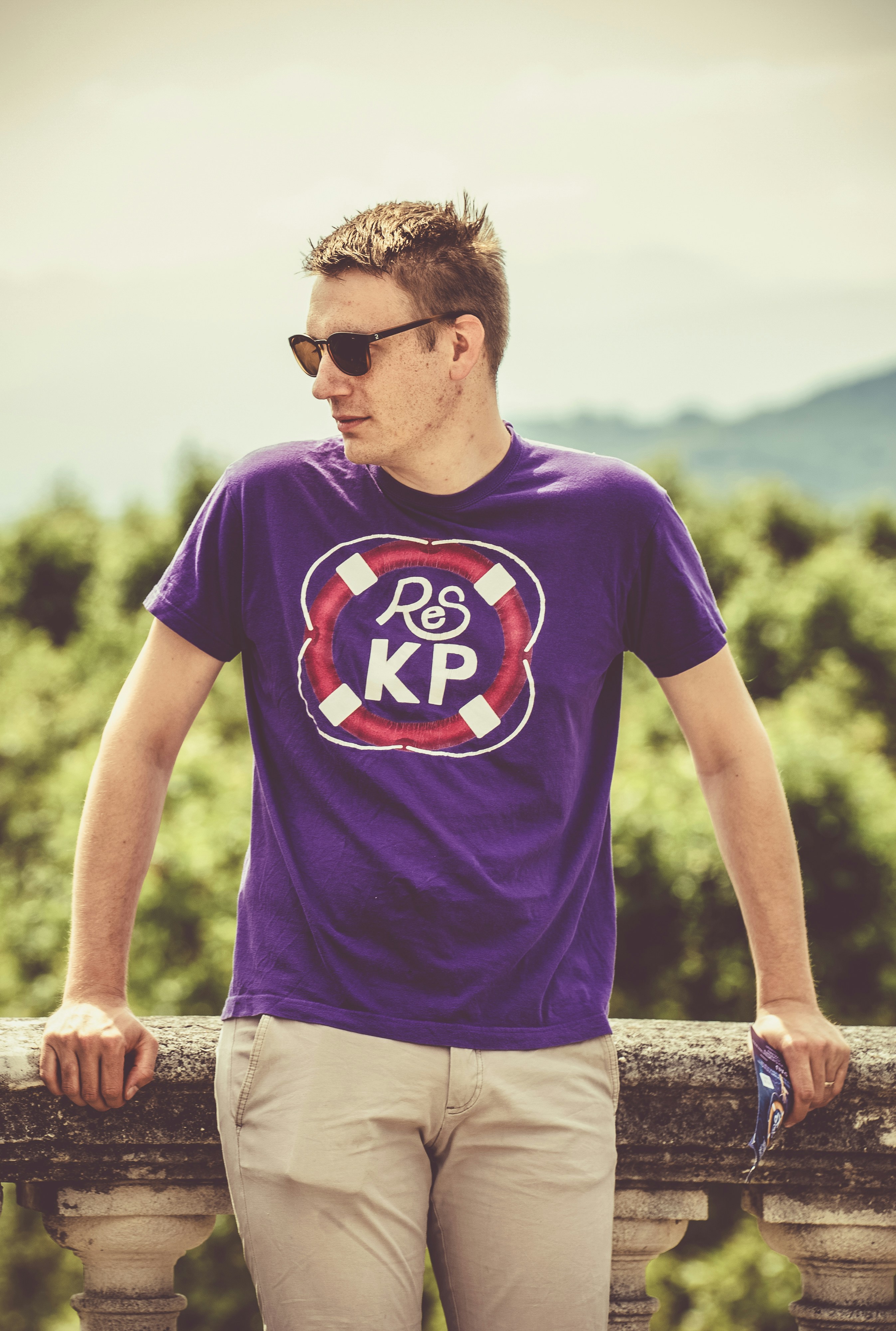 A man wearing a purple shirt and khaki pants