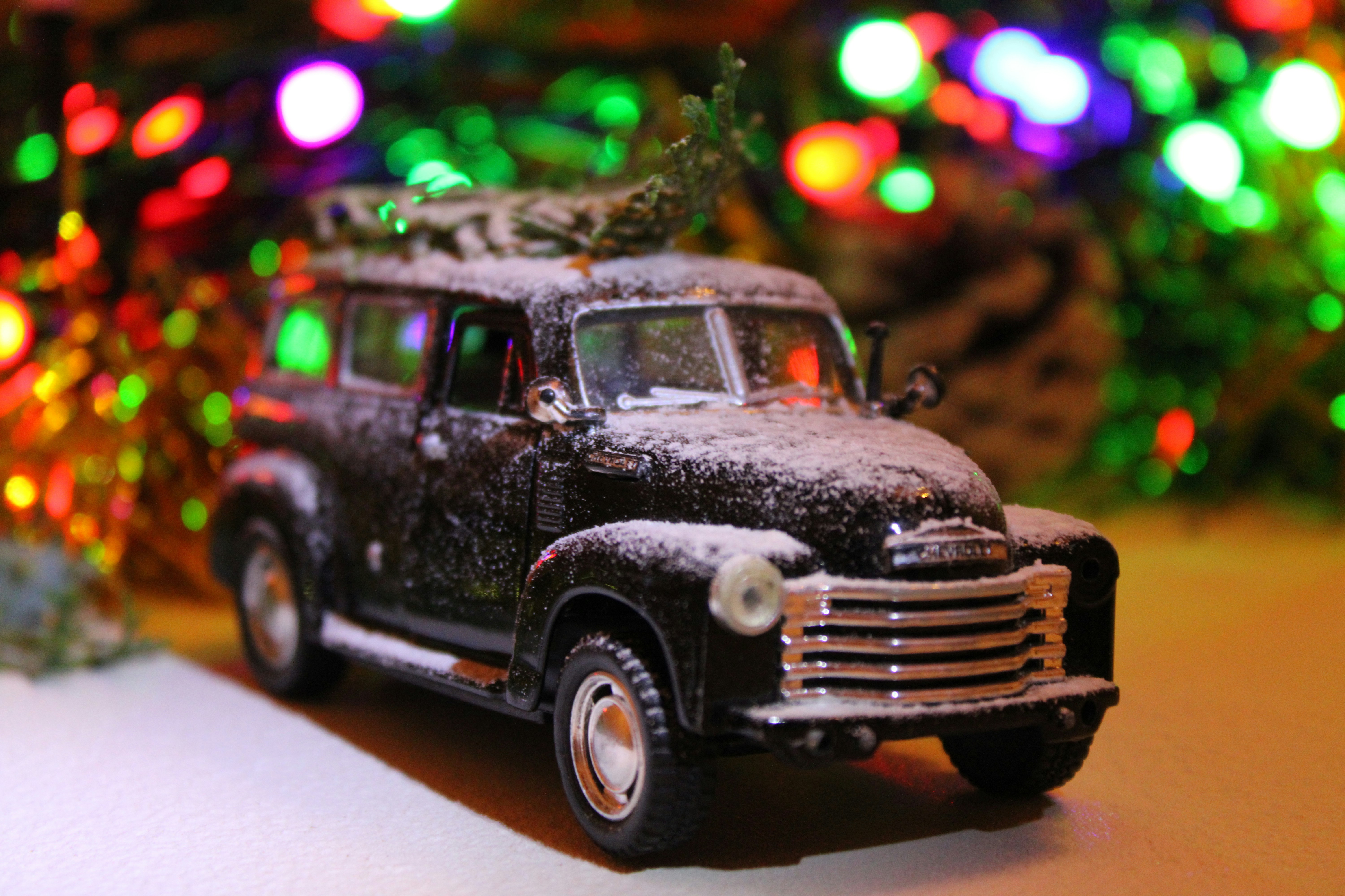 A toy truck with a christmas tree on top of it