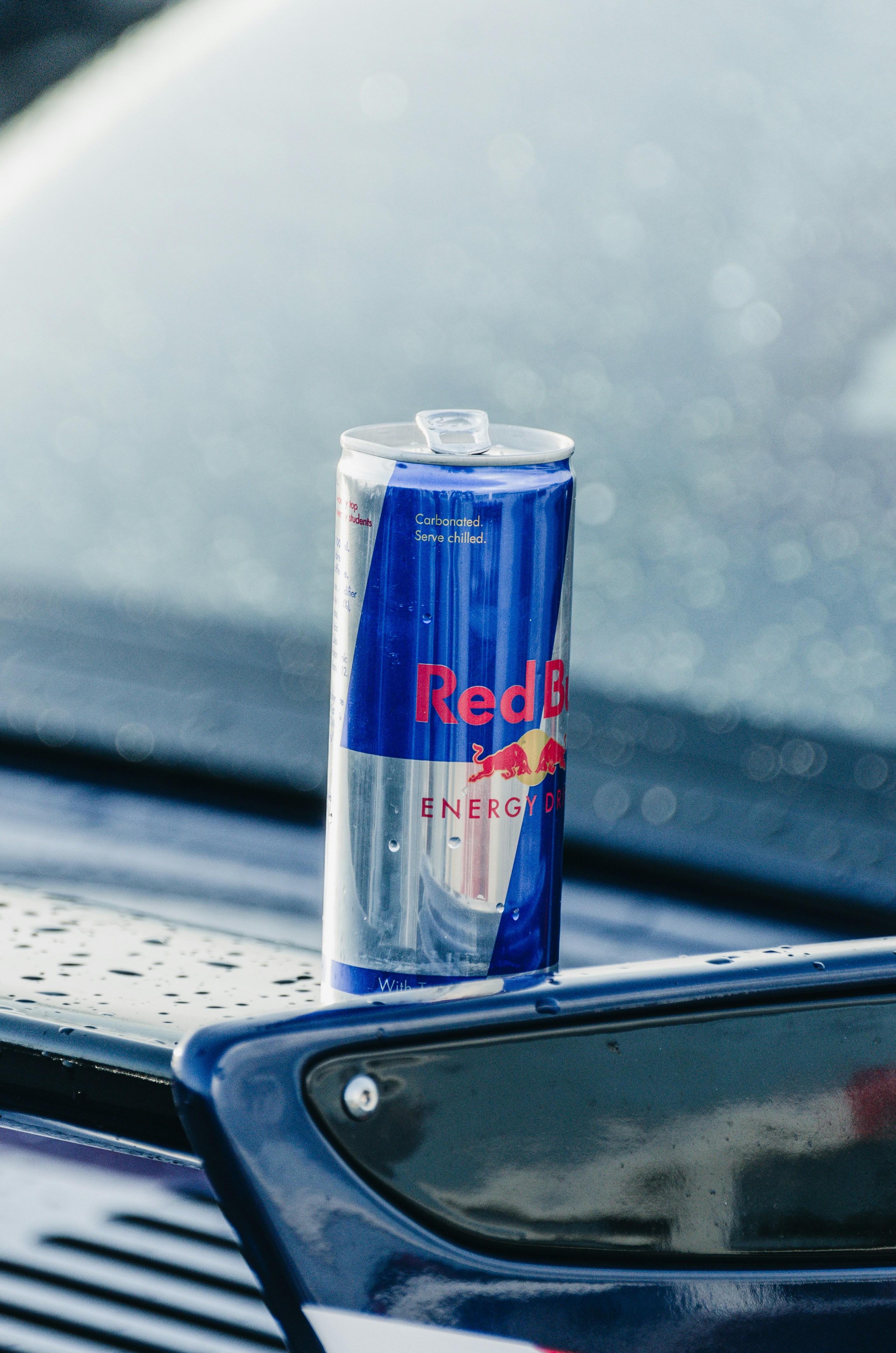 Une canette de Red Bull est posée sur le capot d’une voiture