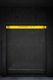 A closed garage door with a yellow sign on it