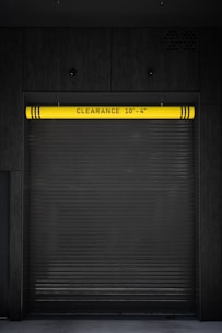 A closed garage door with a yellow sign on it