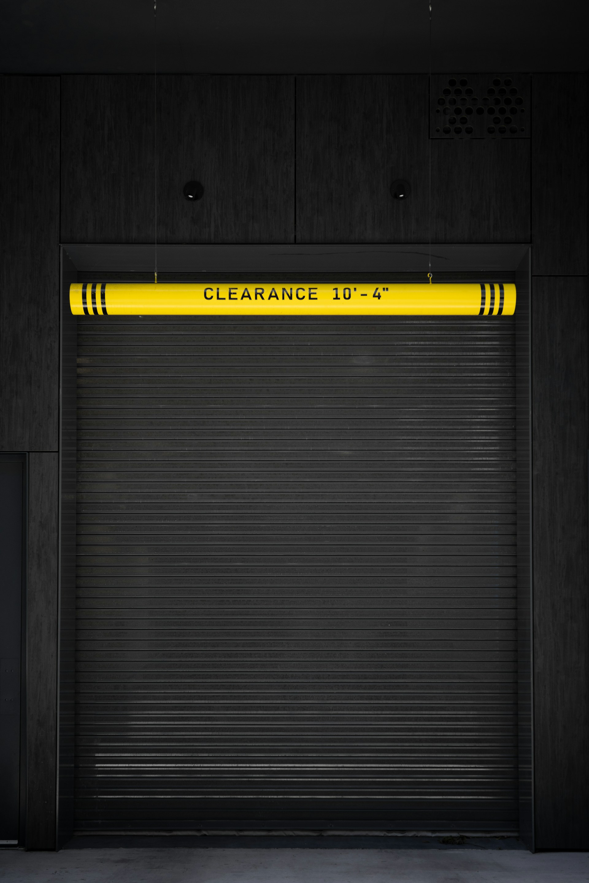 A closed garage door with a yellow sign on it