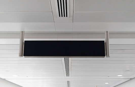 A black and white sign hanging from the ceiling