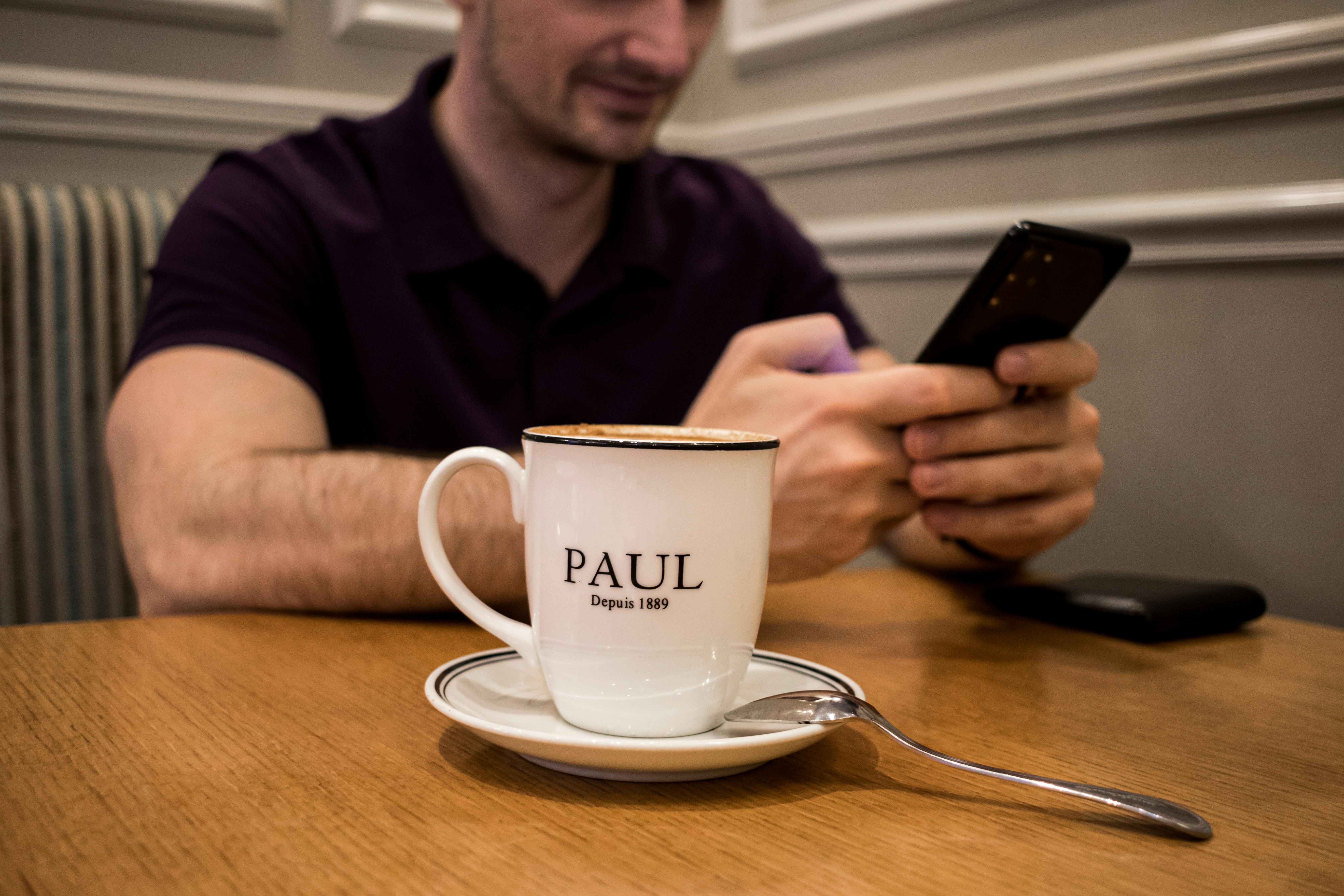 A man sitting at a table using a cell phone