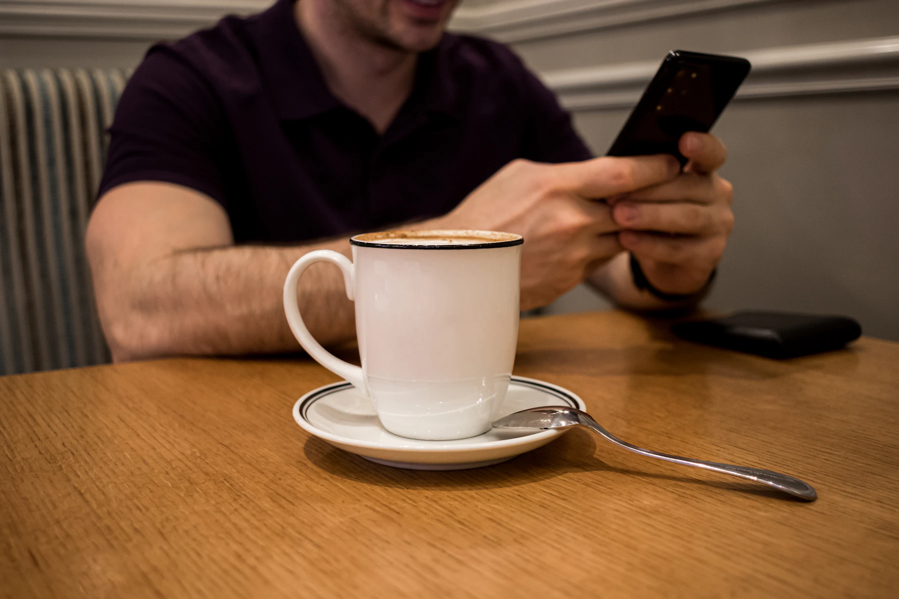 A warm cup of coffee beside a phone showing a daily summary