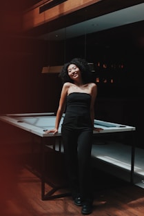 A woman standing in front of a pool table