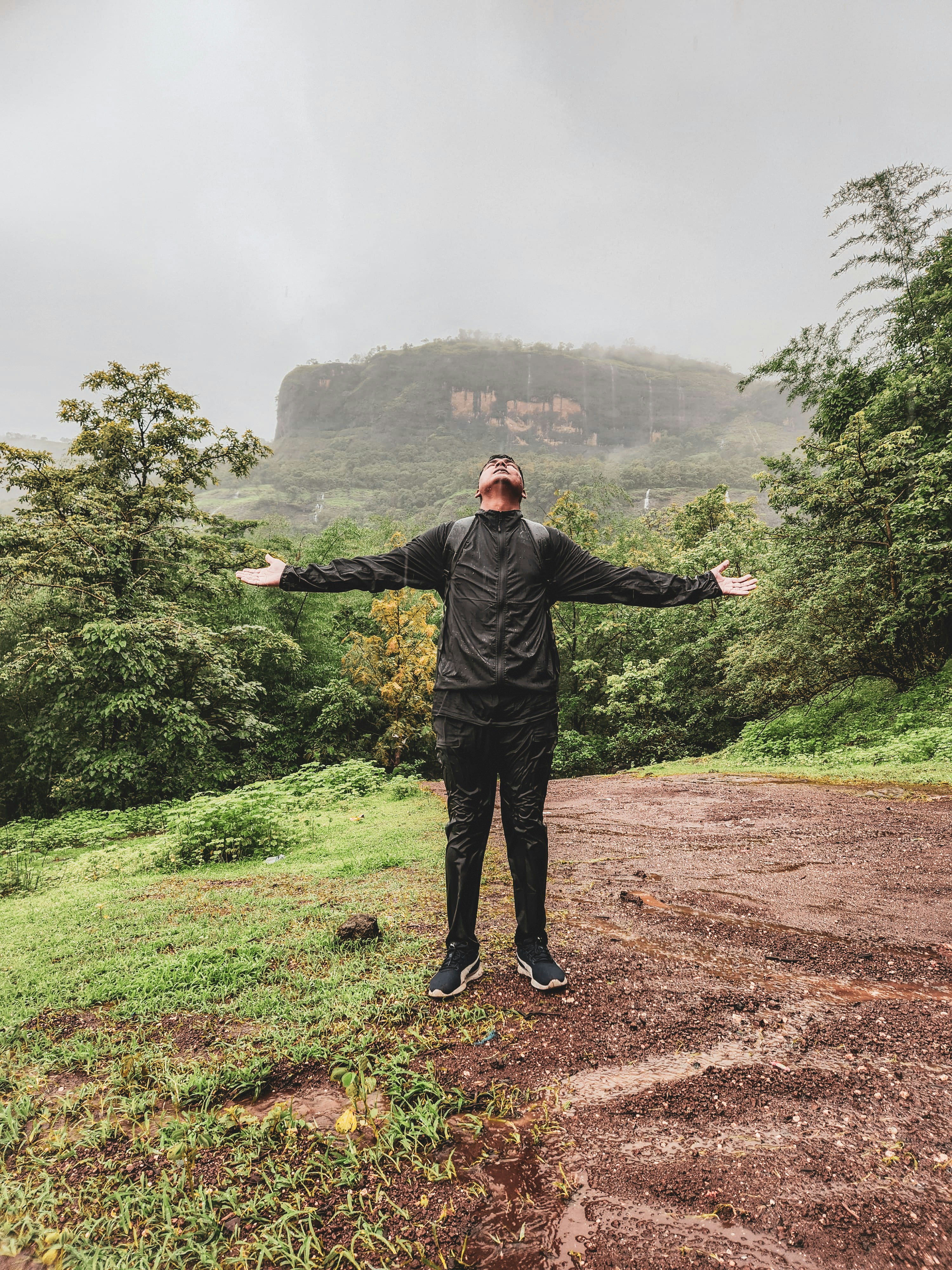 A man standing on top of a dirt road