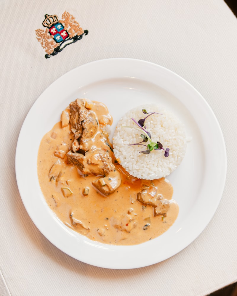 Sliced beef covered in a velvety cream sauce on a plate