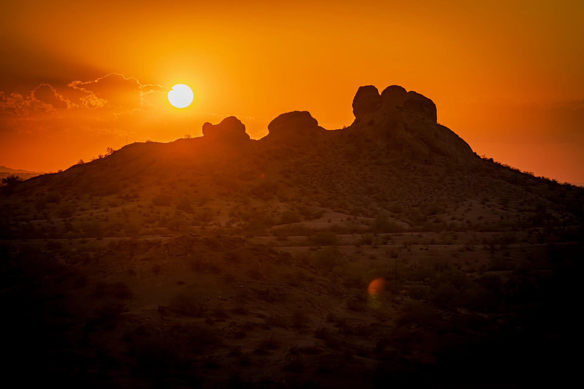 The sun is setting over the mountains in the desert