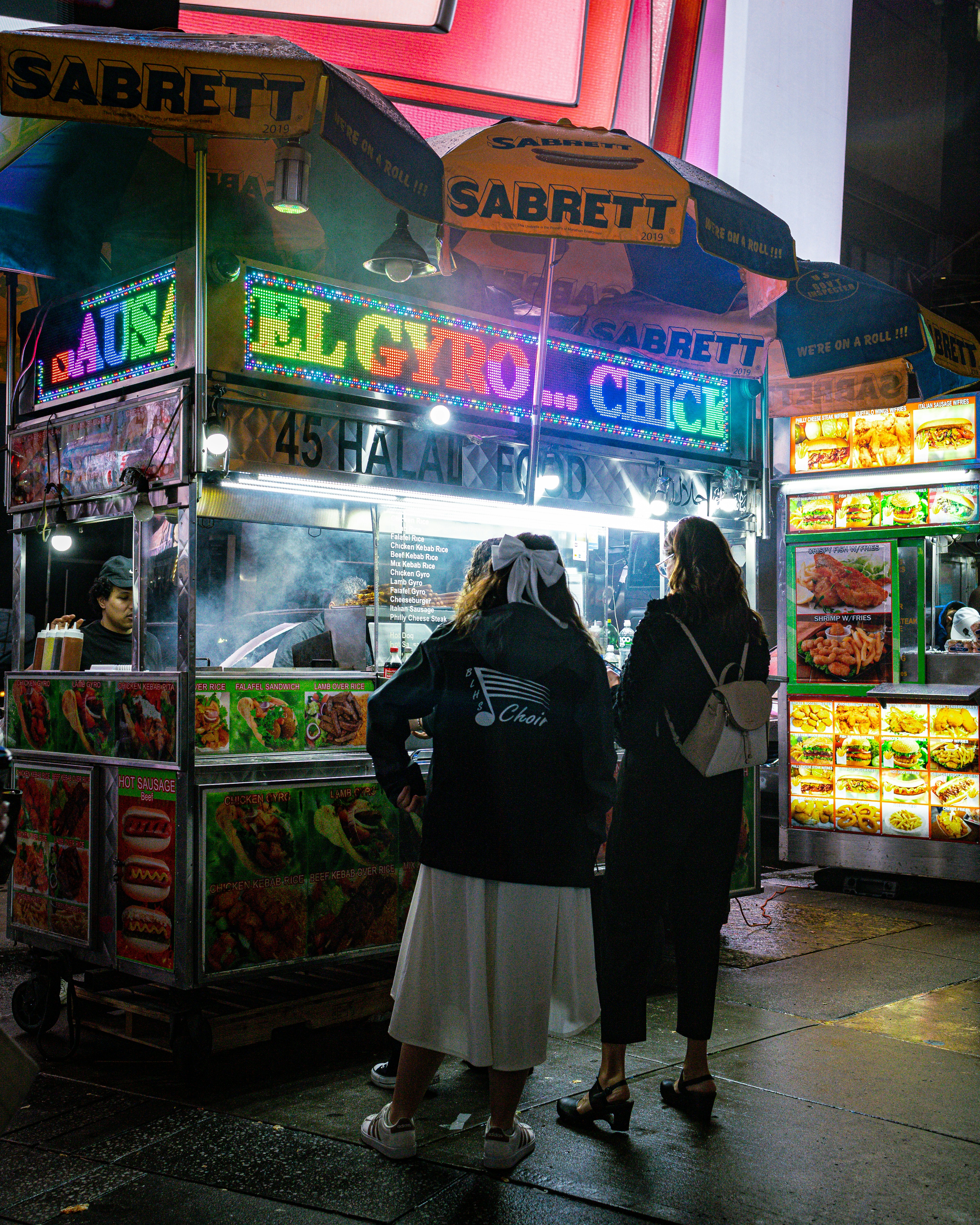 Una coppia di persone in piedi fuori da uno stand gastronomico